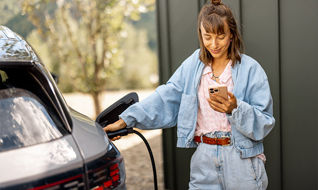Frau lädt E-Auto